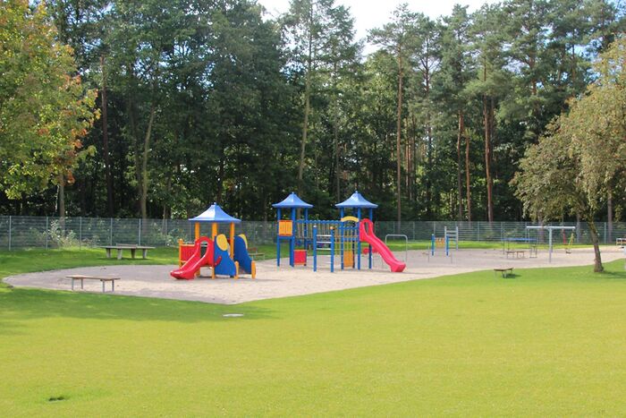 Kinderspielplatz mit Schaukeln, Wippe, Klettergerüst und Sandkiste